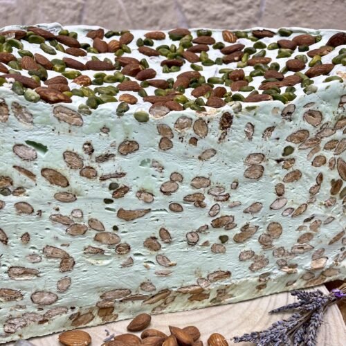 Détail d’une demi-meule de nougat blanc tendre à la pistache