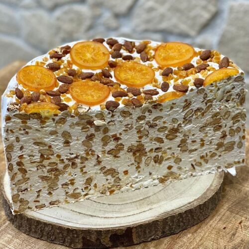 Bloc de nougat blanc tendre à l’orange, garni d’amandes entières et d’oranges confites